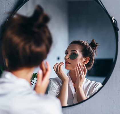 A woman tries to get rid of dark under eye circles with eye cream.