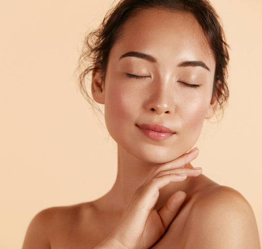 A woman shows her healthy, glowing skin. How to get younger-looking skin.