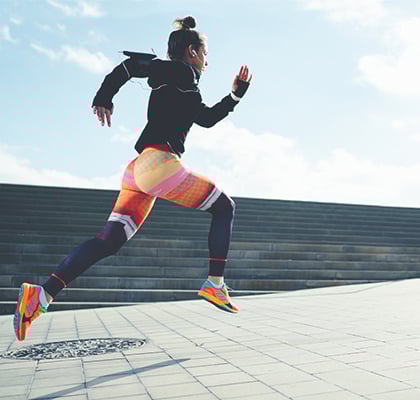 Woman running outside for her daily workout to reach her fitness goals