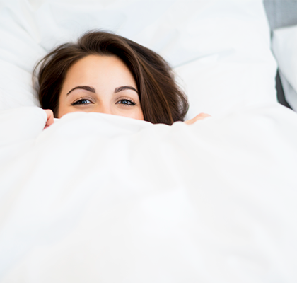 A woman lays in bed as she tries to get sleep as part of her beauty routine.
