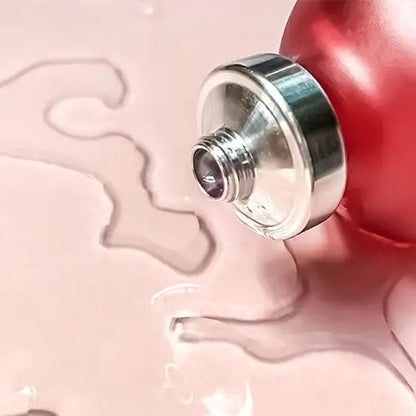 Red bottle with silver cap on a pink background
